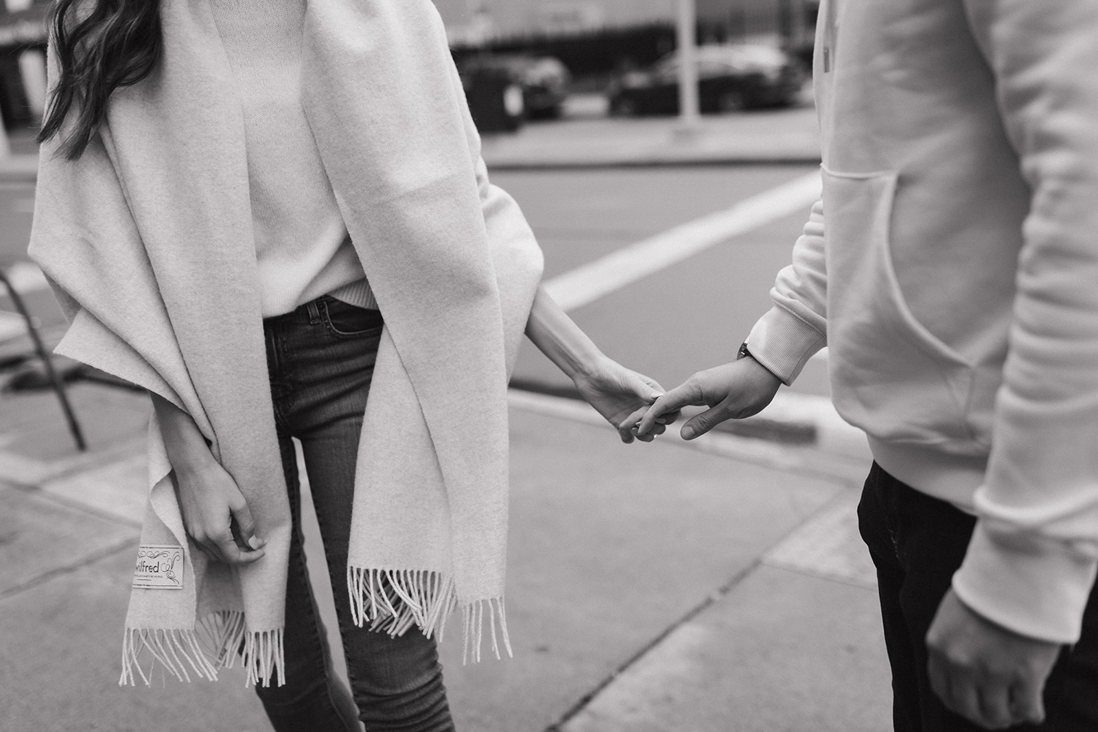 Couple holding hands as they walk downtown