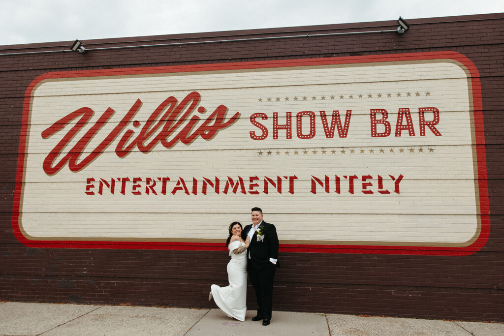 Couple posing for photos from their Detroit wedding at Willis Show Bar