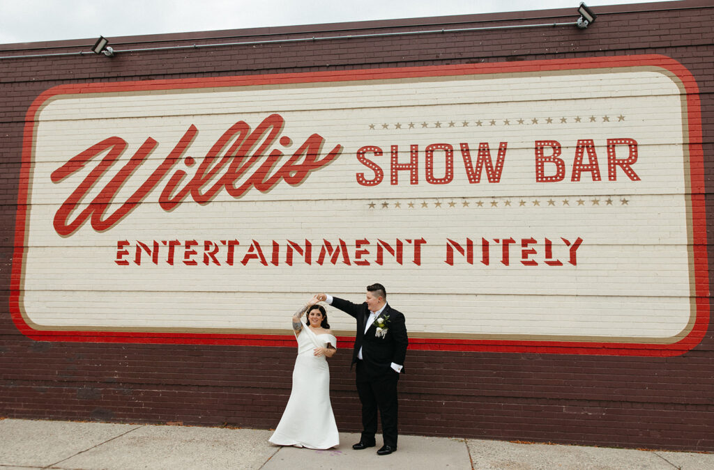 Couple posing for photos from their Detroit wedding at Willis Show Bar