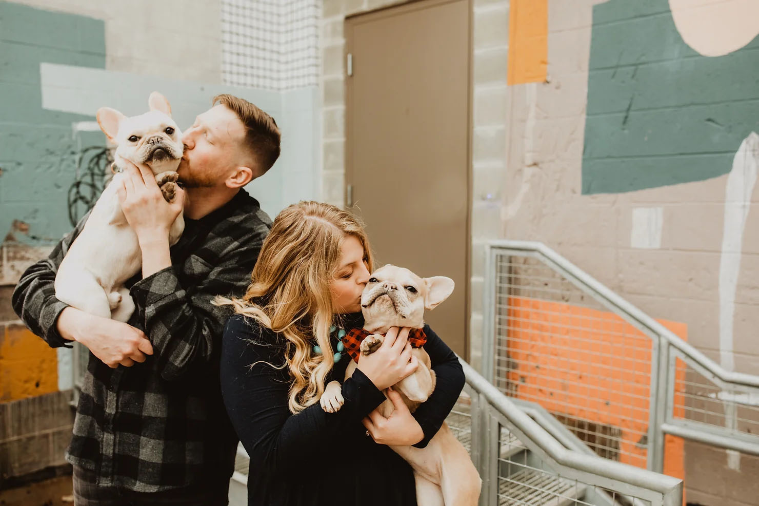 Couple and kissing their two pugs for their Michigan engagement photos