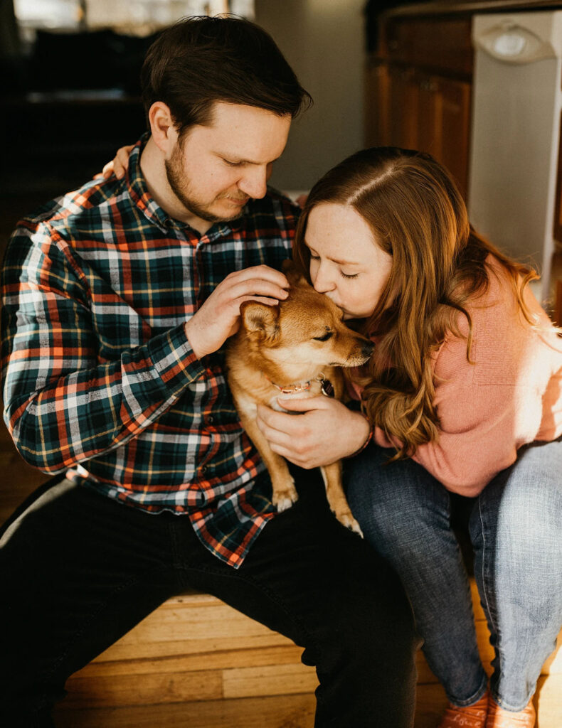 Couple holding their dog for their engagement photos