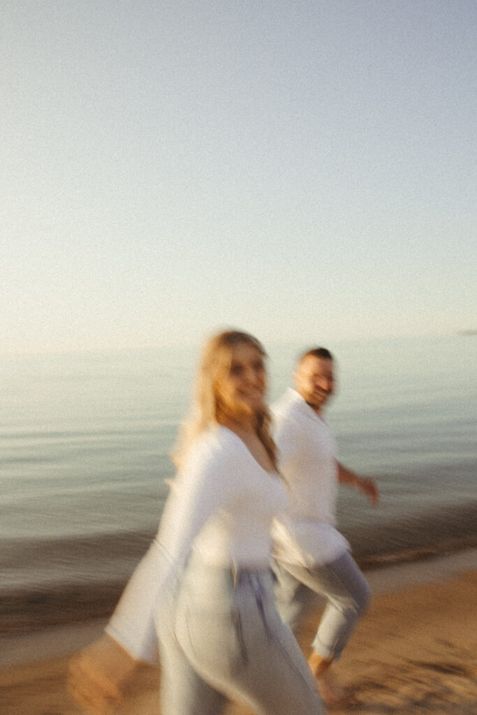 Blurry photo of couple walking along the shoreline of a beach