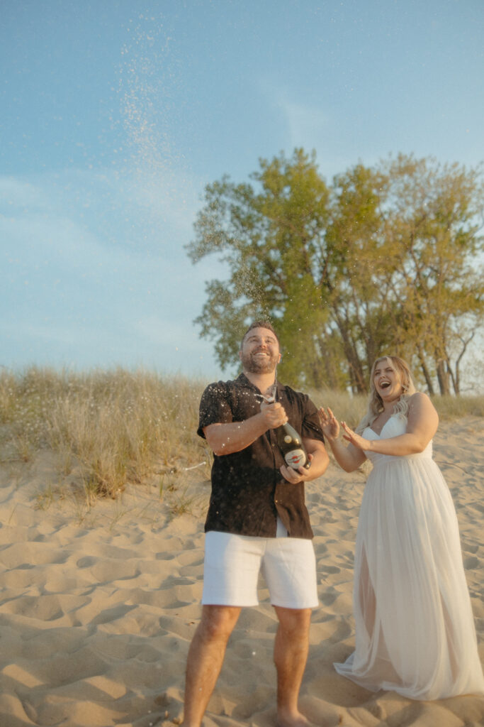 Couple popping champagne during their engagement session