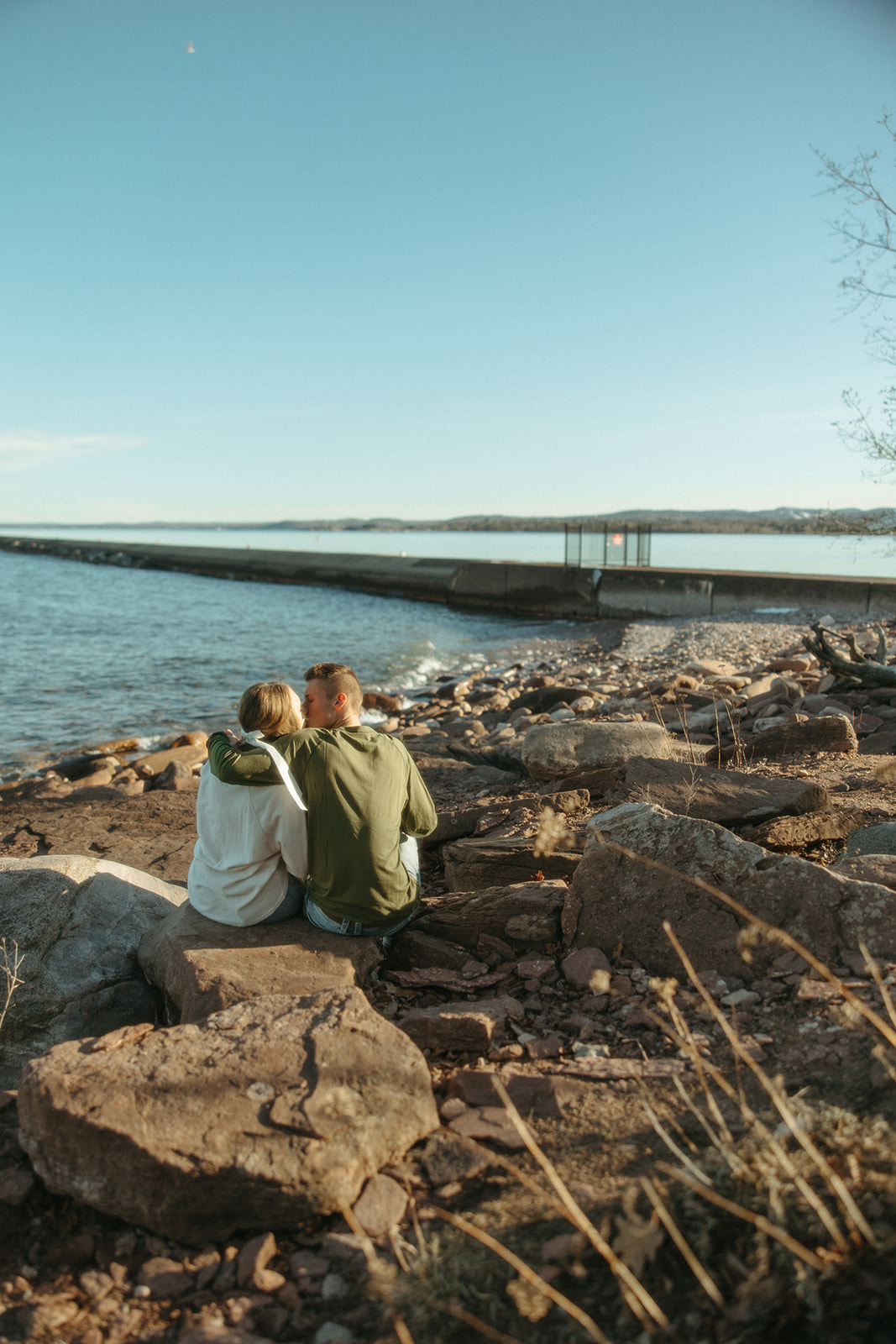 Couple admiring the black rocks and Lake Superior during their Marquette Michigan engagement photos