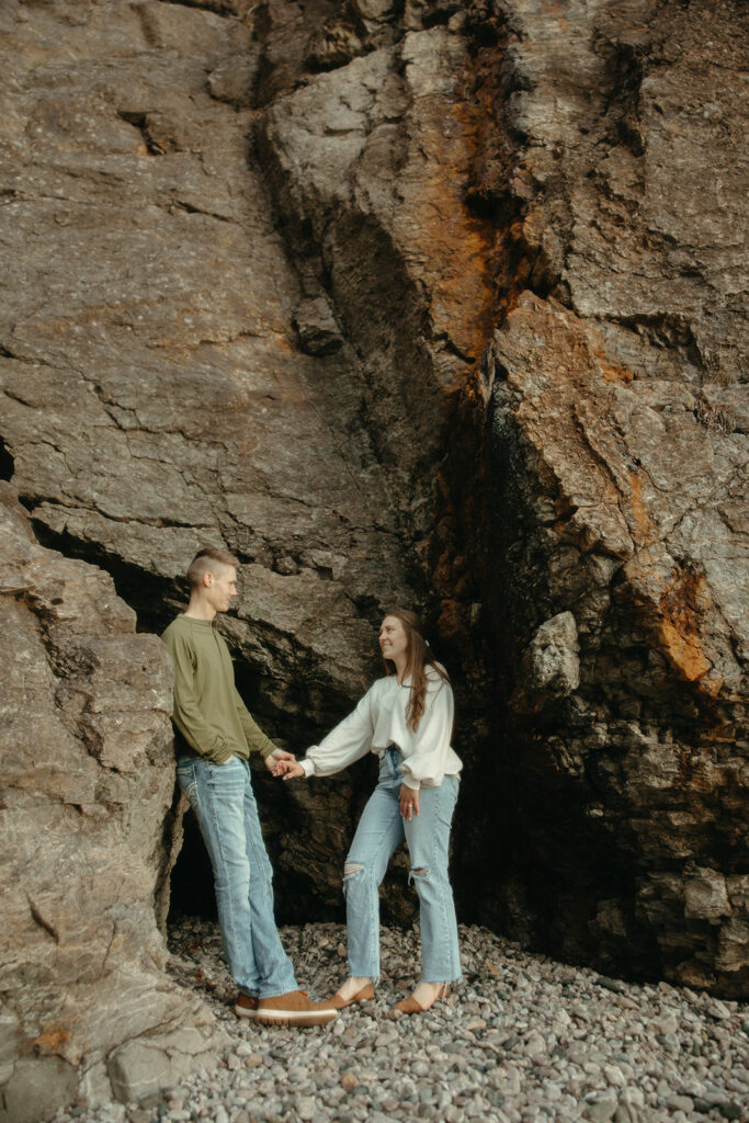 Man and woman exploring rock formations in Marquette Michigan