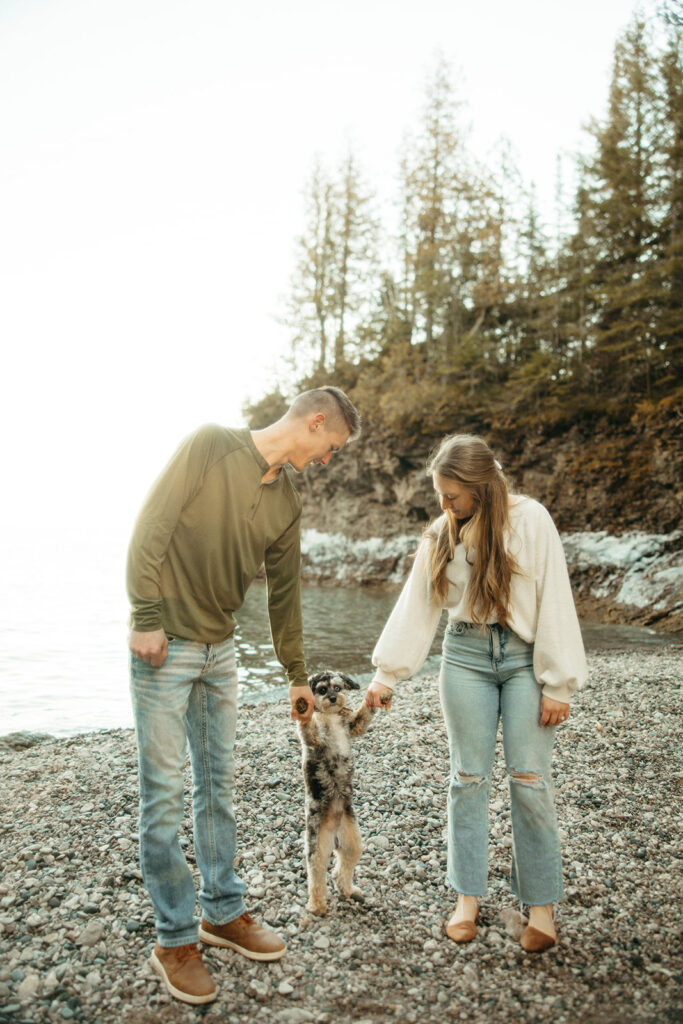 Man and woman holding hands with their small dog