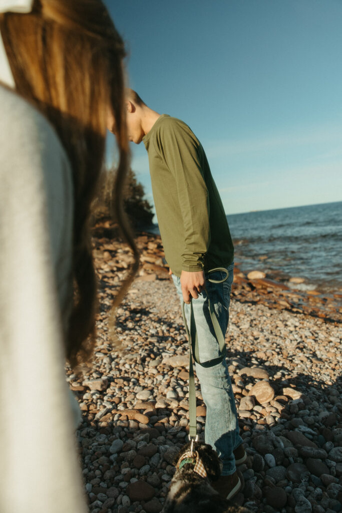 Couple and their dog exploring Black Rocks for their Marquette Michigan engagement photos