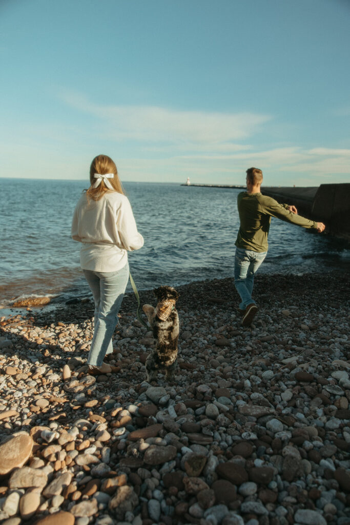 Couple and their dog throwing stones in Lake Superior 