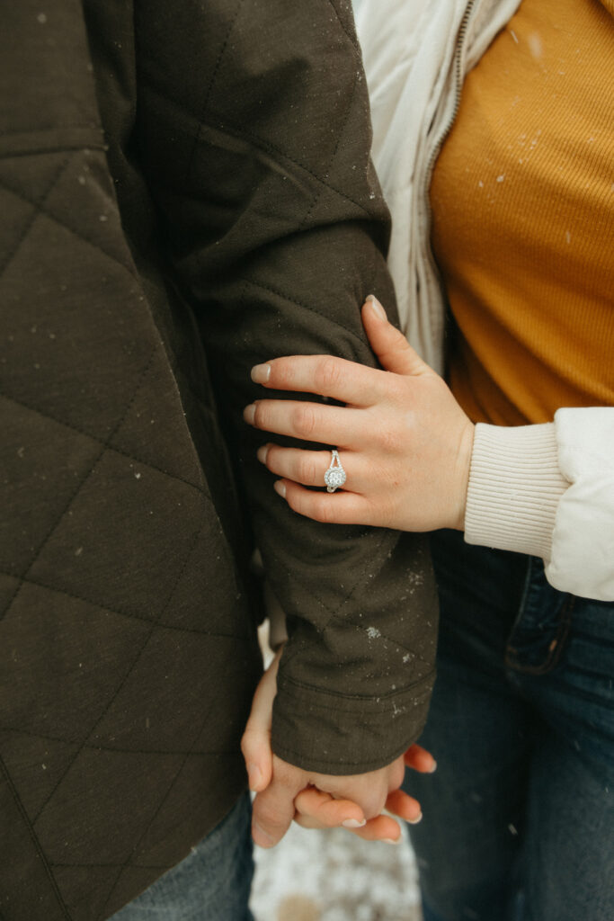 Close up shot of woman's engagement ring during their photoshoot.
