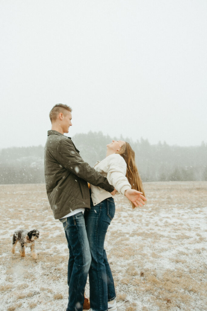 Man, woman and their dog being playful for their engagement session