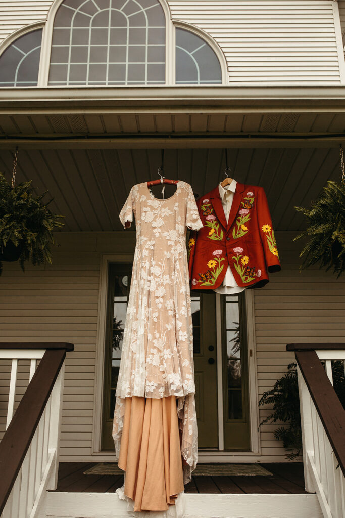 Brides wedding dress and grooms suit hanging for photos