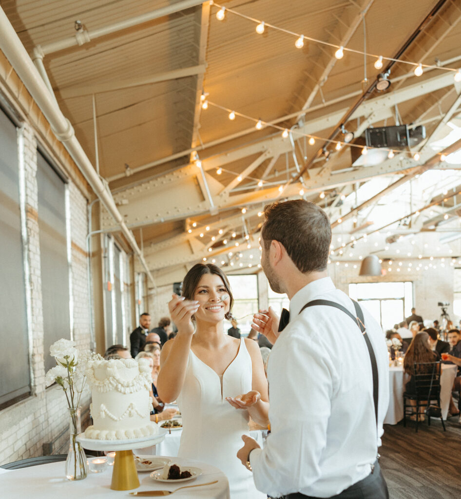 Bride and groom feeding each other their wedding cake