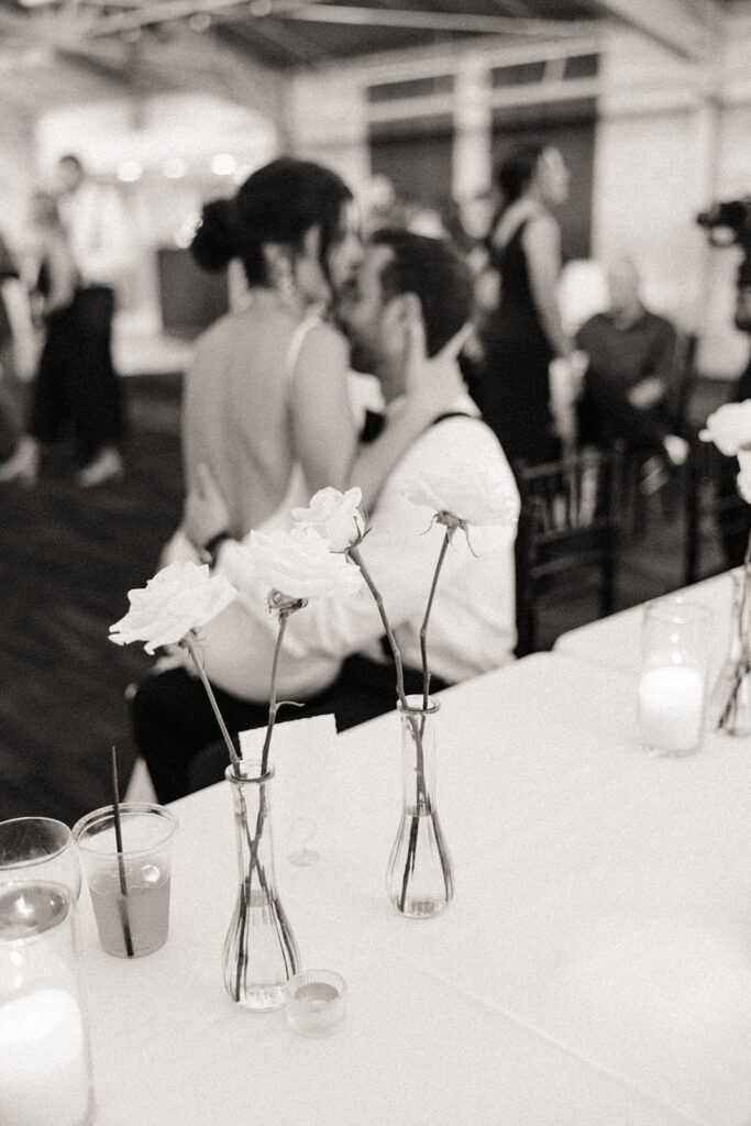 Black and white photo of a bride sitting on her grooms lap during their Baker Lofts Holland MI wedding reception