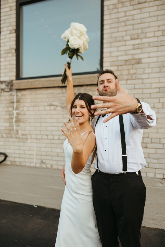 Bride and groom showing off their wedding rings at Baker Lofts Holland MI wedding venue