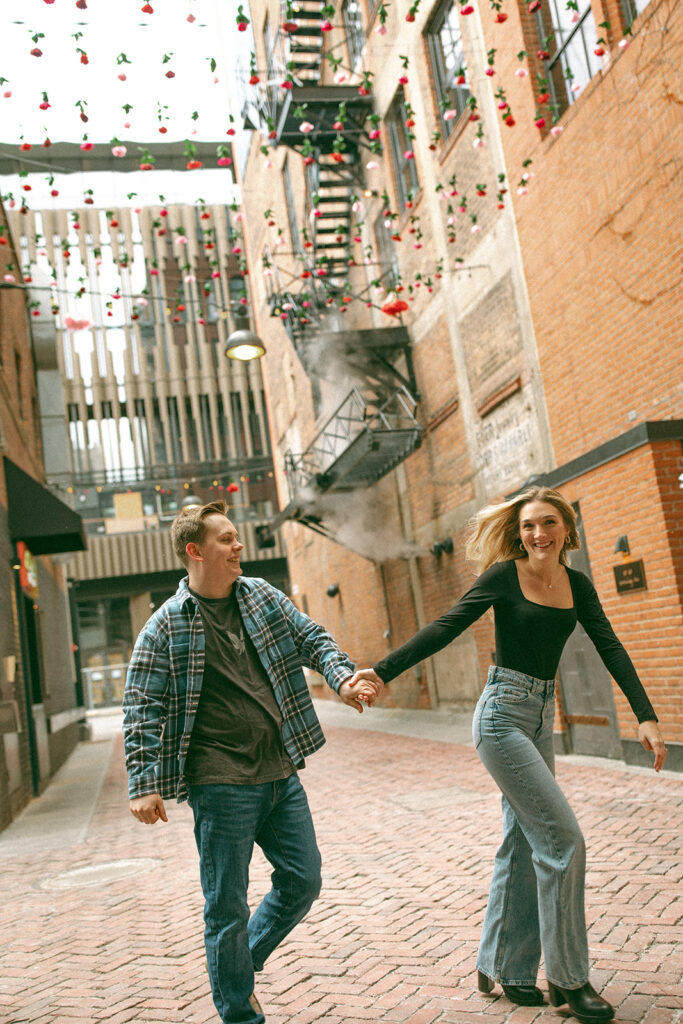 Couple walking down The Belt alleyway for their downtown Detroit engagement photos.