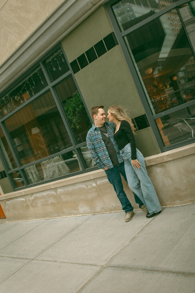 Couple leaning up against a building during their engagement session