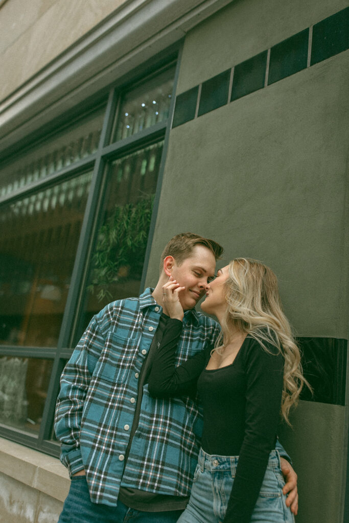 Woman caressing her fiancés face during their downtown photoshoot