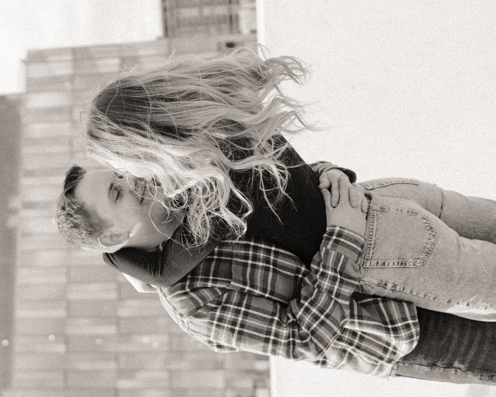 Black and white photo of a couple on a parking garage rooftop for their engagement photoshoot