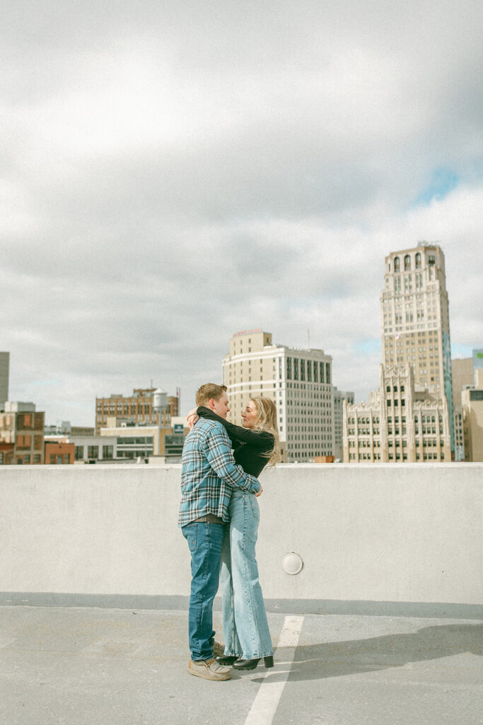 Couple up on a parking garage rooftop for their downtown Detroit engagement photos at Z Lot