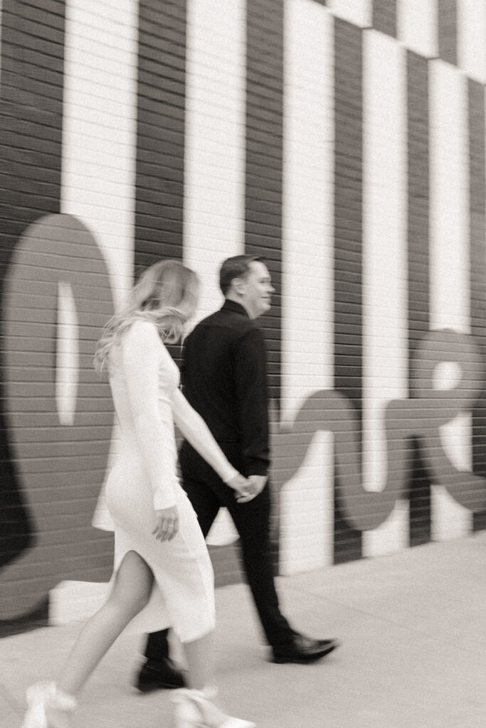 Blurry black and white photo of a couple walking during their downtown Detroit engagement photos