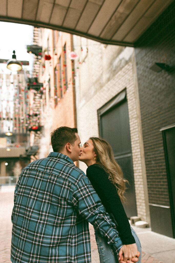Couple kissing during their downtown Detroit engagement session in The Belt alleyway