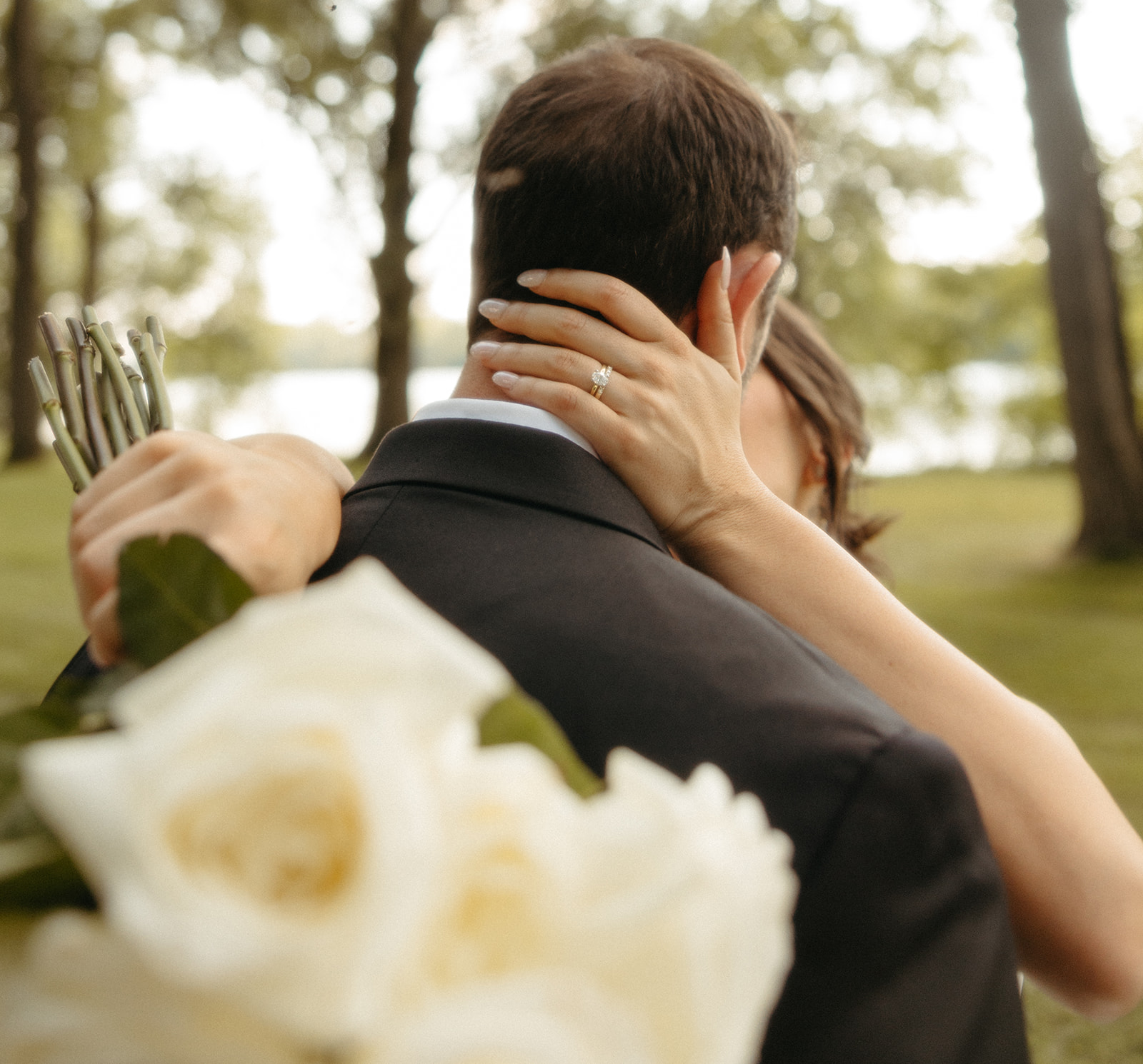 Close up shot of a bride showing off her wedding ring and kissing her groom