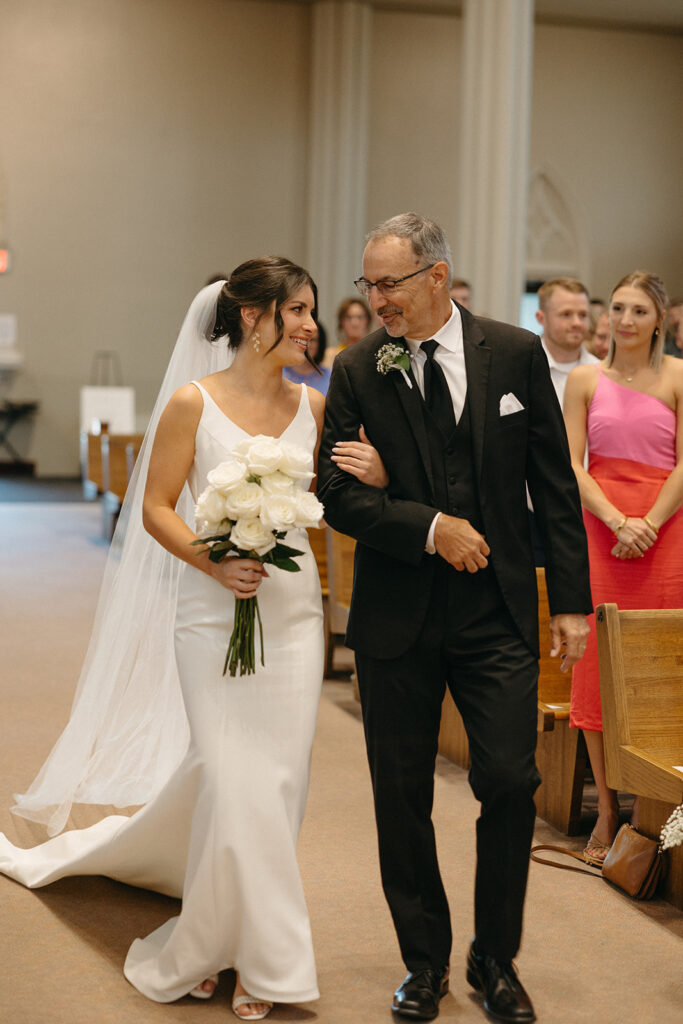 Bride being walked down the aisle by her father during her Grand Rapids wedding ceremony