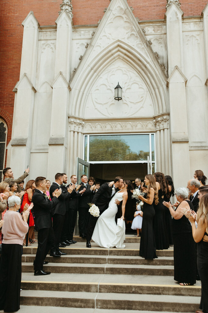 Bride and groom kissing during their Grand Rapids wedding ceremony exit