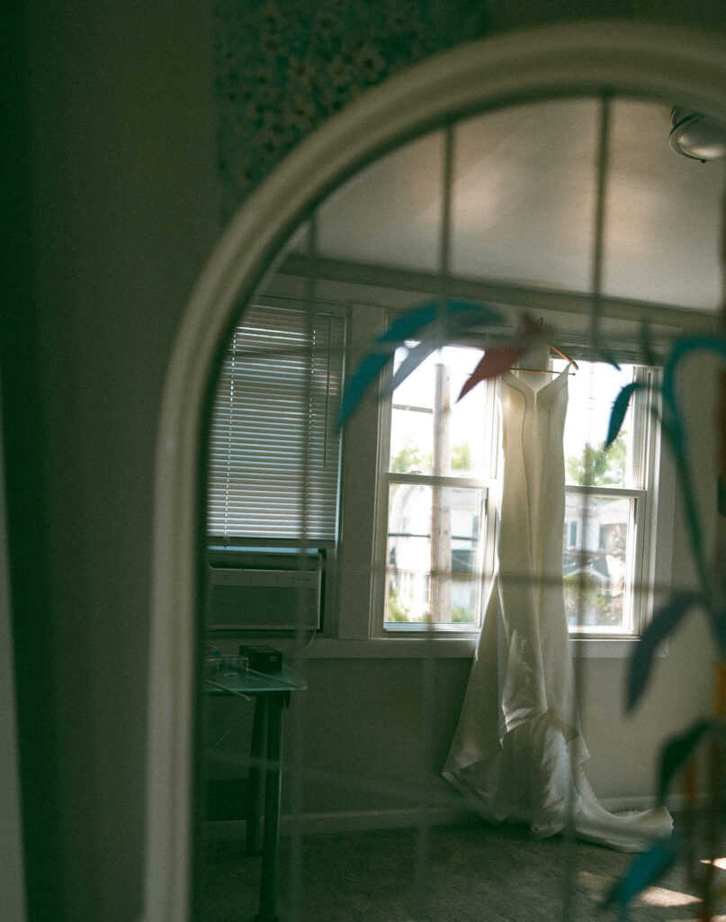 Wedding dress hanging against a window