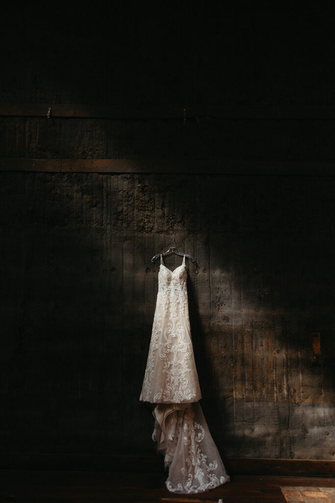 Wedding dress hanging on a wall with the light shining on it