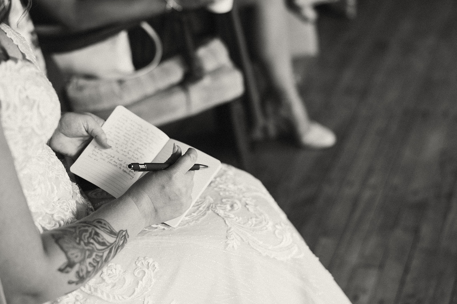 Black and white photo of a bride writing her wedding vows to her soon to be husband 