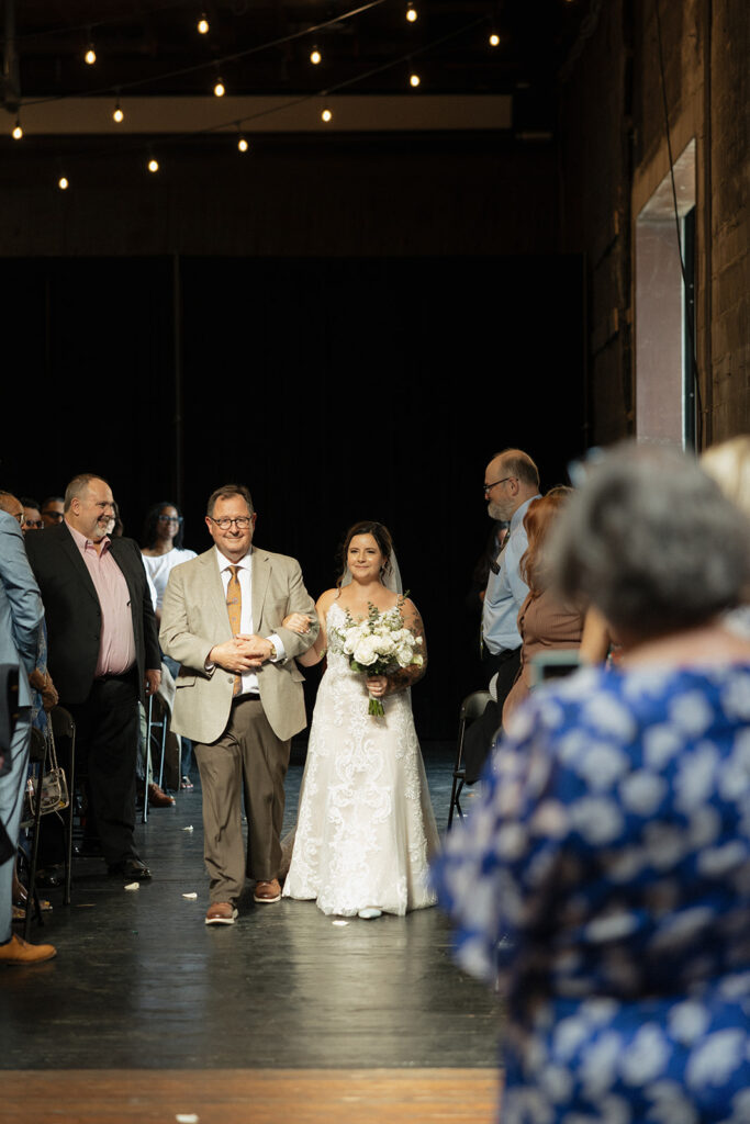 Bride being walked down the aisle by her father for her Jam Handy wedding ceremony in Detroit, Michigan