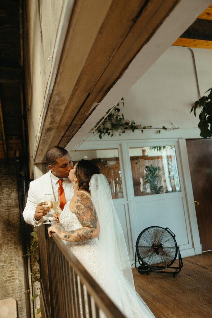 Bride and groom kissing on a balcony at Jam Handy wedding venue in Detroit, Michigan
