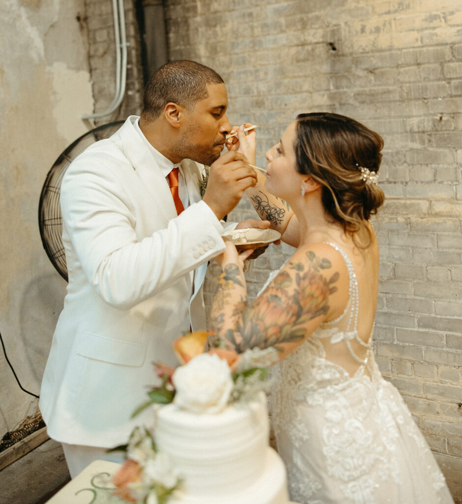 Bride and groom eating a slice of their wedding cake together 