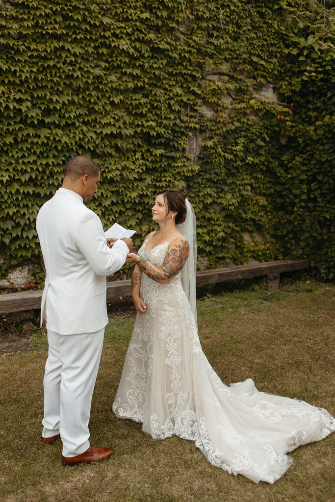 Groom reading his personal vows to his bride after their first looks outside of Jam Handy wedding venue in Detroit, Michigan