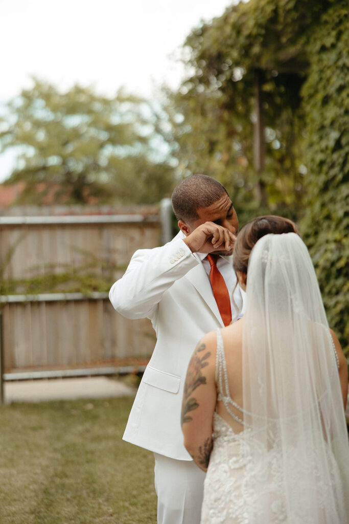 Groom crying as his soon to be wife reads her vows to him outside of Jam Handy wedding venue in Detroit, Michigan