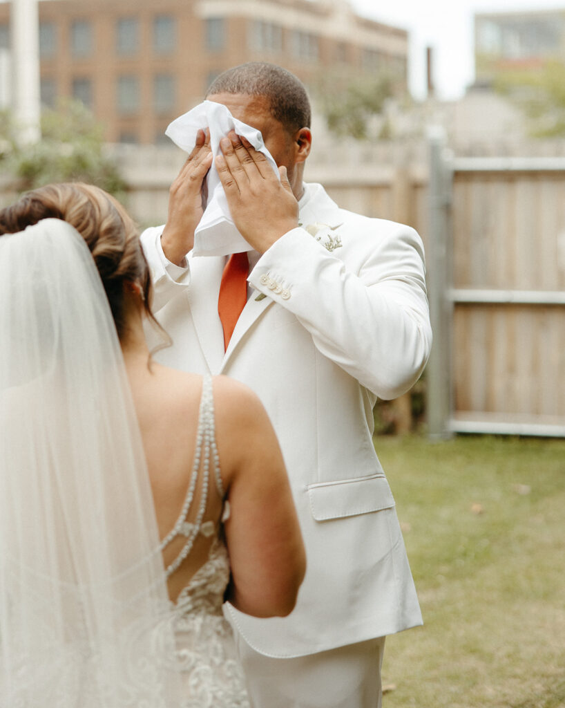 Groom getting emotional during first looks and private vows outside of Jam Handy wedding venue in Detroit, Michigan