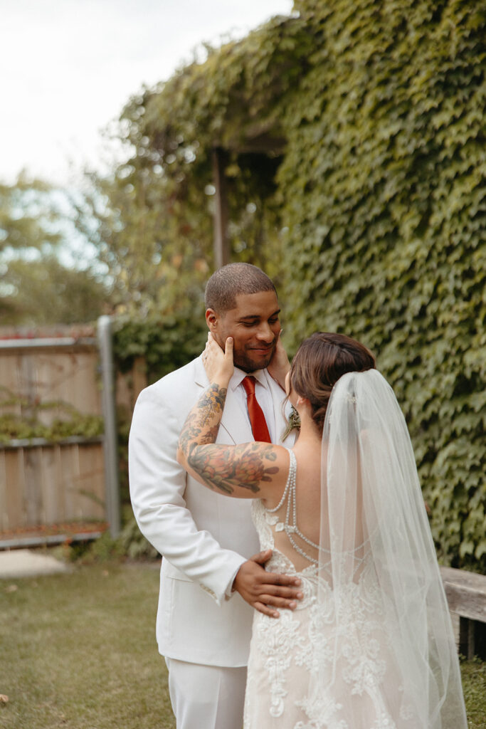 Bride and groom embracing each other during their intimate first looks outside of Jam Handy wedding venue in Detroit, Michigan