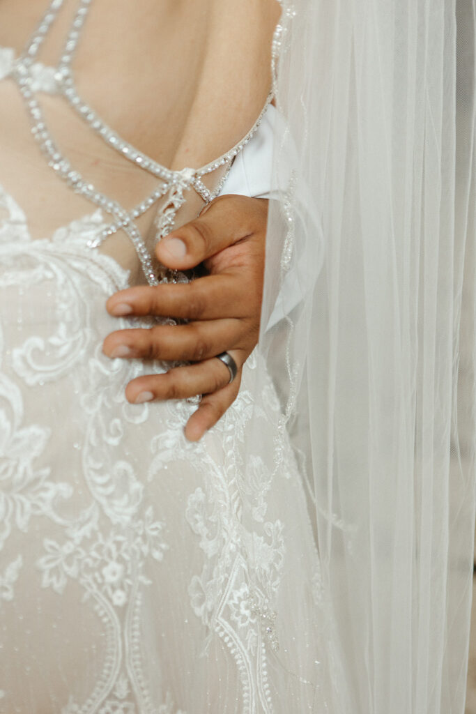 Close up shot of a groom holding his brides waist