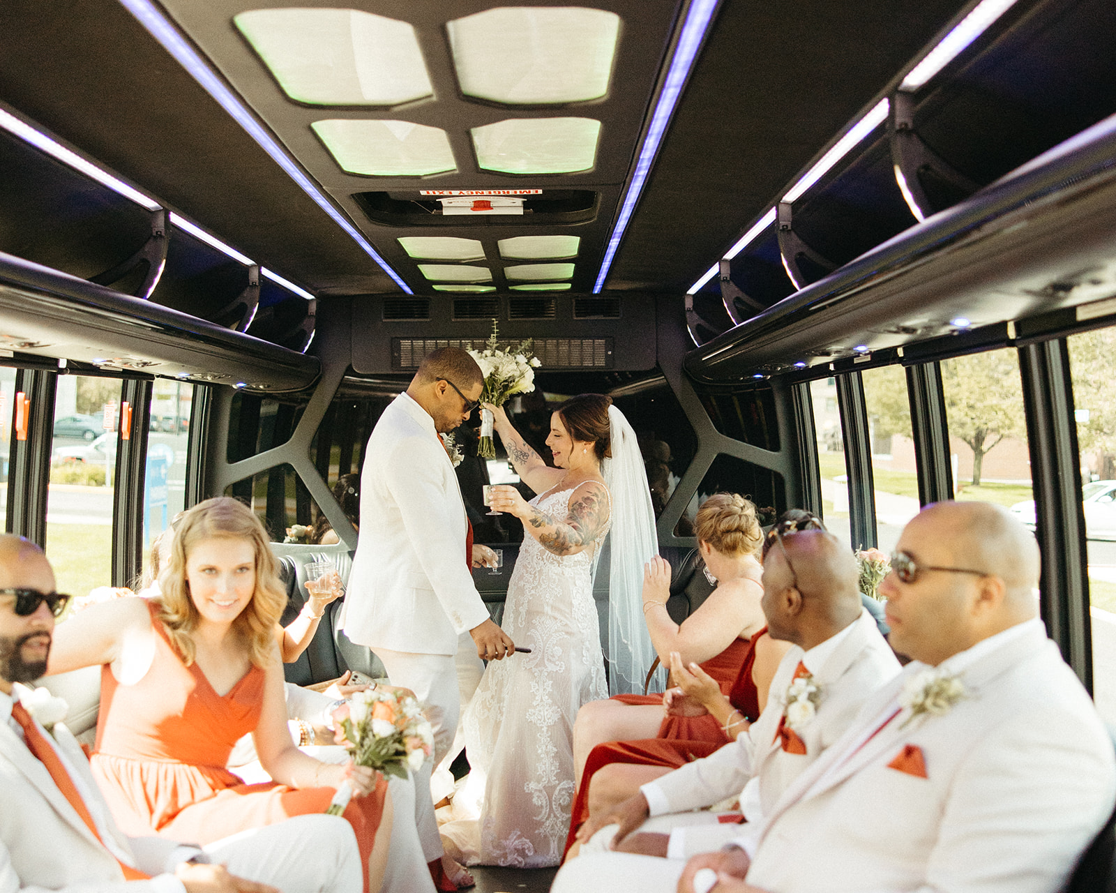 Bride, groom and their entire wedding party of a party bus