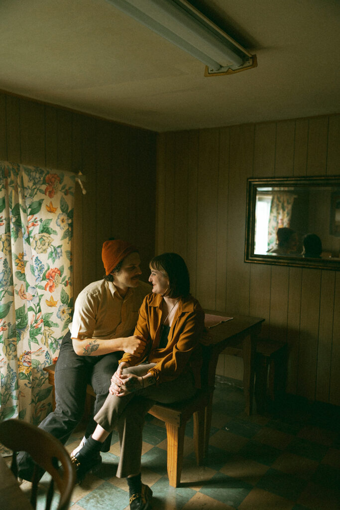 Man and woman smiling at each other during their at-home couples shoot