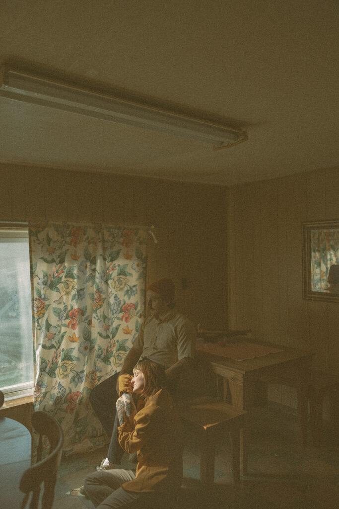 Man and woman posing for photos in their kitchen during their at-home vintage couple photoshoot in Michigan