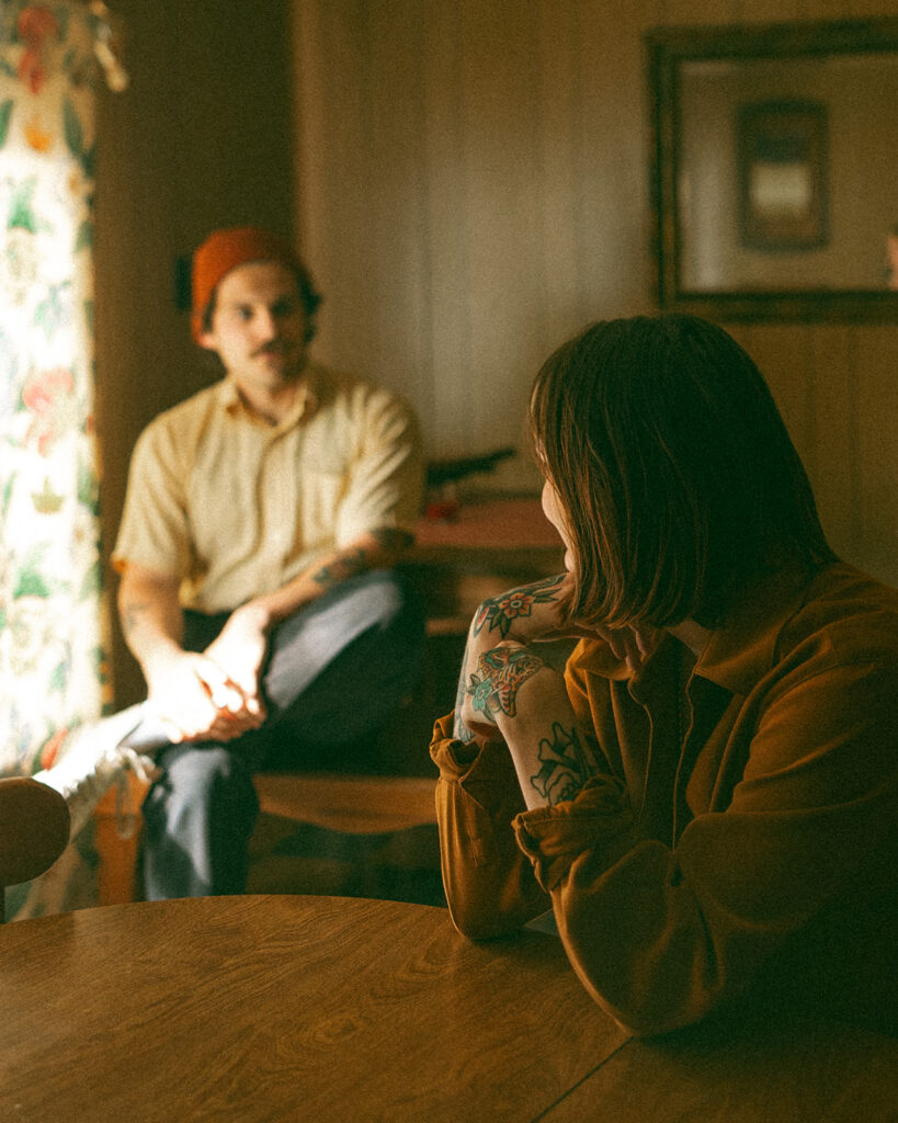 Man and woman posing for photos in their kitchen during their at-home vintage couple photoshoot in Michigan