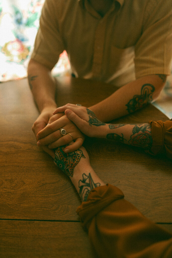 Man and woman holding hands at a kitchen table