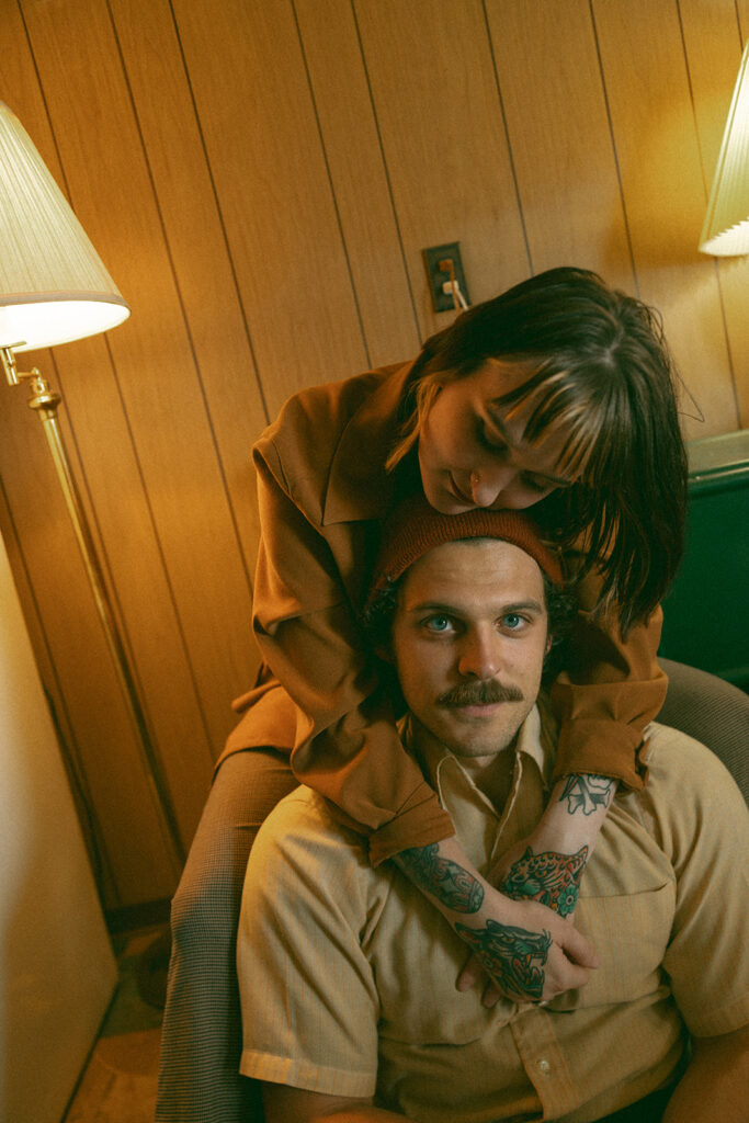 Woman leaning over her partner during their at-home vintage couple photoshoot in Michigan