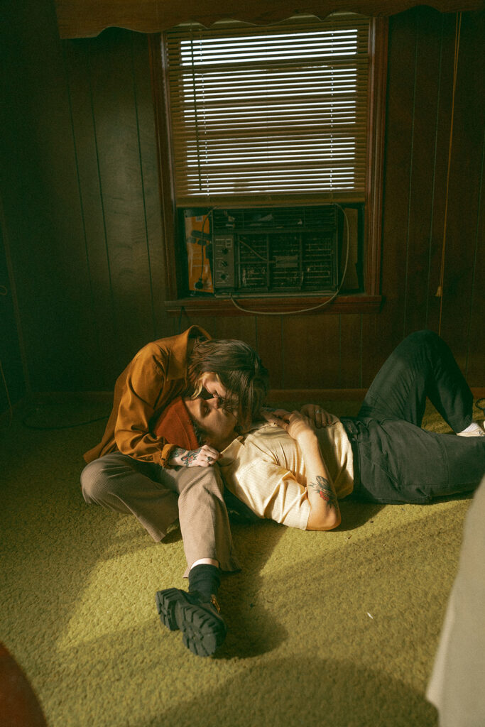 A man laying on his partners lap during their at-home vintage couple photoshoot in Michigan