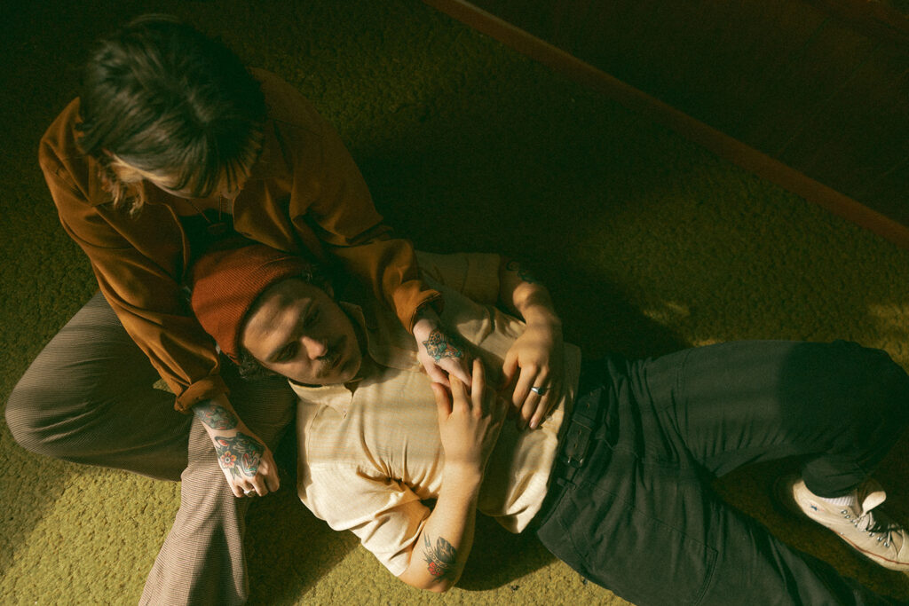 Couple laying on a living room floor during their at-home vintage couple photoshoot in Michigan