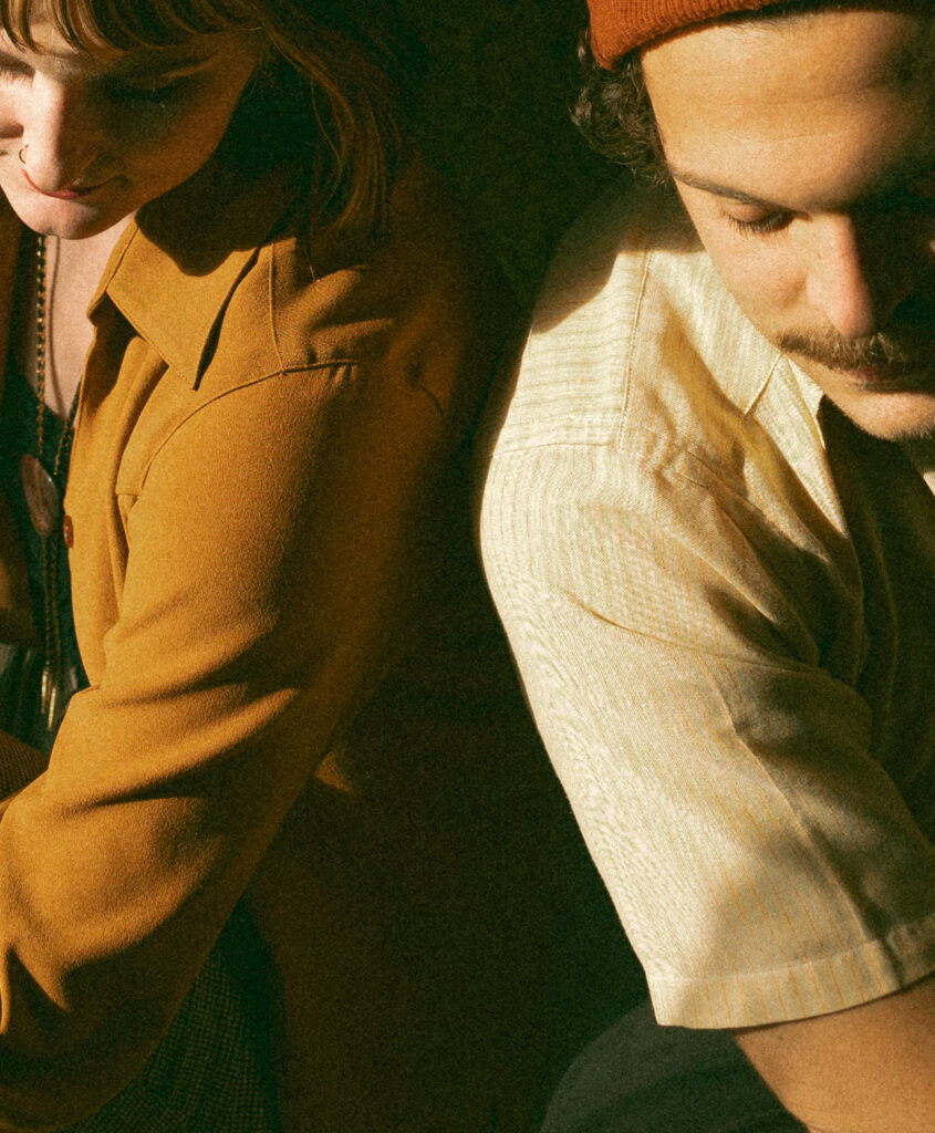 Close up shot of a couple sitting together with the sun shining through from a nearby window