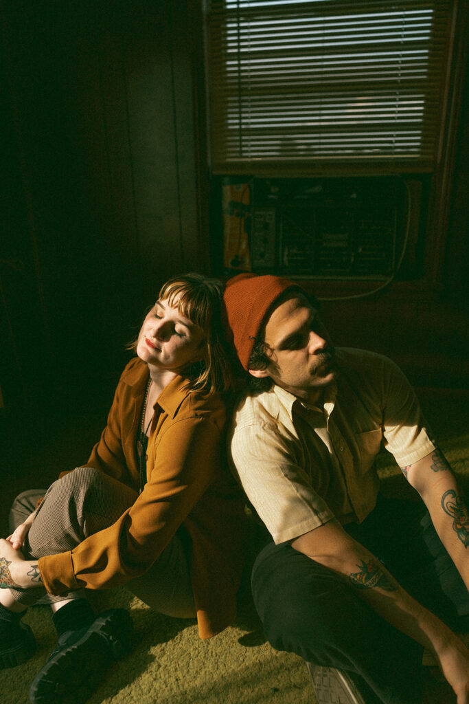 Man and woman leaning against each other during their at-home vintage couple photoshoot in Michigan