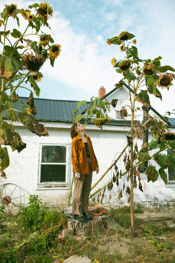 Woman admiring dead sunflowers 